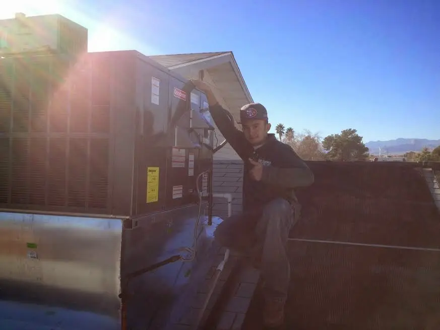 HVAC technician performing AC Tune-Up on a rooftop unit in Allendale